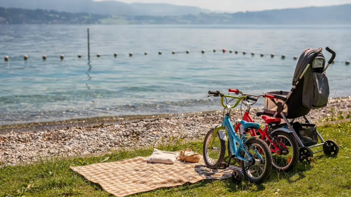 Familienurlaub am Bodensee mit Kindern am Ufer mit Fahrrädern, Kinderwagen und Picknickdecke