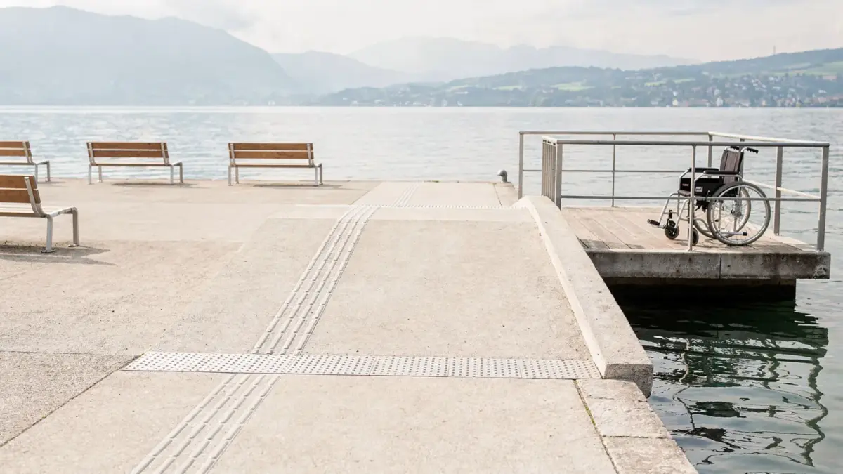 Barrierefreie Promenade am Bodensee mit Rampe, taktilem Boden und Seeblick für einen Ausflug.