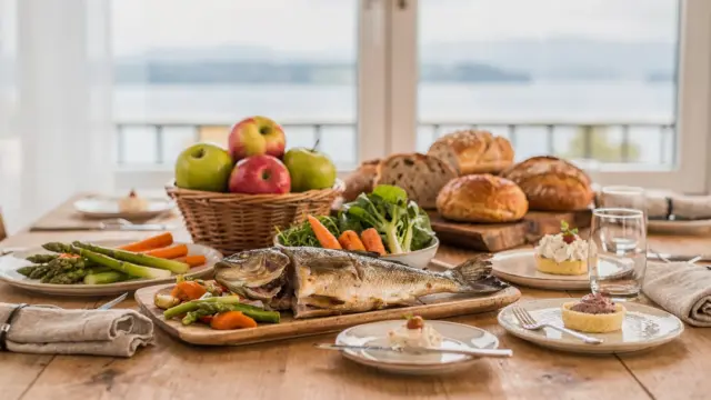 Regionale Küche am Bodensee mit Fisch, Obst, Gemüse und typischen Spezialitäten auf einem gedeckten Tisch