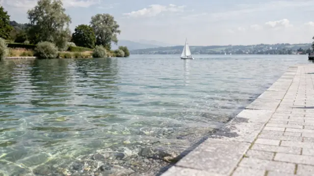 Sommer am Bodensee mit ruhiger Uferpromenade, klarem Wasser und Segelbooten zum Thema beste Reisezeit
