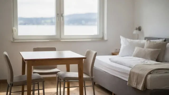 Ferienwohnung am Bodensee mit Tisch, Bett und Fensterblick für Last-Minute-Buchungen
