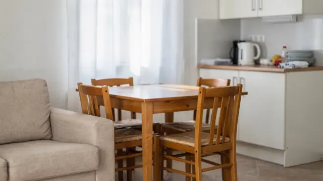 Günstige Ferienwohnung Ausstattung mit einfacher Küche, Tisch und sparsamer Einrichtung